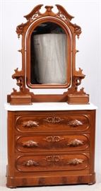 Lot#31, AMERICAN ANTIQUE, MAHOGANY MARBLE TOP DRESSER AND MIRROR, C1850,Dresser having a carved wood arched top mirror with open pediment and carved acanthus leaf crest.  Two candle shelves on each side attached to the mirror frame. Two attached jewelry drawers on each side at the bottom. All resting on a white marble top. Bottom section has three full width drawers with carved leaf and fruit design wood pulls and burl facades. Footed base.