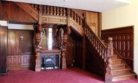 Lot#2222, CARVED MAHOGANY DRAGON-FORM FIREPLACE & STAIRCASE, H 11' 10", L 16' 11"Having paneled walls with carved mahogany staircase that wraps and rises above the fireplace. The fireplace has carved turned columns supporting two fully carved dragons that visually support the staircase. 24' linear feet.   5 - Additional Color pictures can be viewed on computer. This is disassembled and wrapped in a storage facility in Paw Paw Michigan.