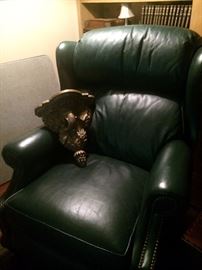 One of two dark green leather recliners; elephant wall shelf