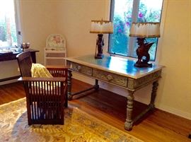 Antique Mission/Arts and Crafts Stickley Era Morris Oak Armchair with Leather Seat
29" x 24.5" x 37" seat 17"h AND Antique Spanish Colonial  Desk Heavily carved with faux marble painted plank top. Two Drawers with Beautifully Carved Lion's Head on Each Drawer Front 56" x 35" x 31" AND Pair of Antique Italian Renaissance Heavily Carved Gargoyle Table Lamps with Hand-Painted Parchment Shades Detailed w/Gold Leaf Design and Embellished w/Silk Trimmings by Dagmar 
16" x 27" x 11"



