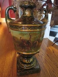 LARGE CERAMIC HAND PAINTED URN WITH HUNT SCENE  - THIS HAS A LARGE SILK ARRANGEMENT
