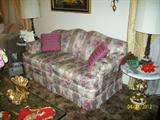 Sofas as well as marble topped end tables and a huge ornate glass topped coffee table