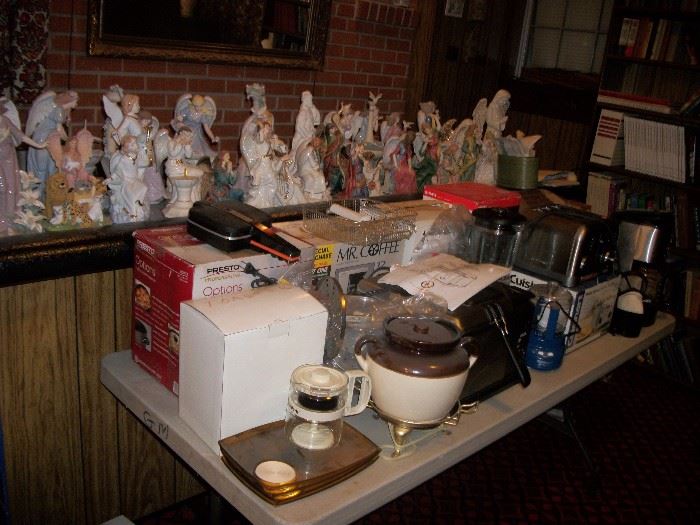 table full of misc kitchen small appliances and bar top covered with porcelain angels