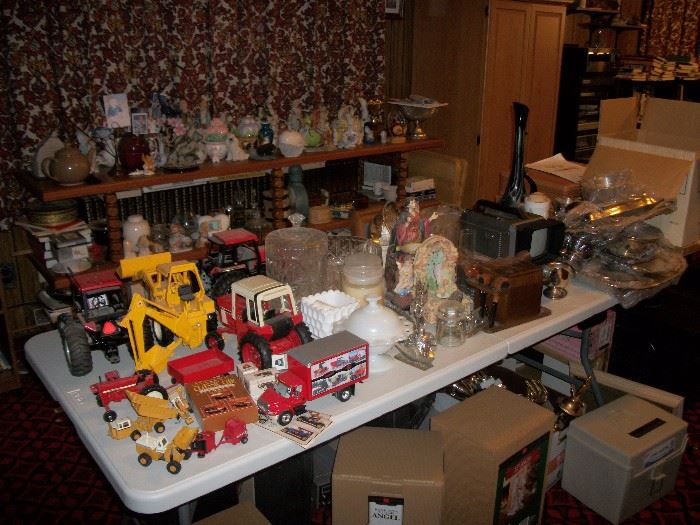 Table covered with metal toy trucks and tractors, silverplated items, crystal and misc