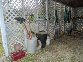 Old tool box, galvanized and plastic trash cans, shovel, rake, etc.