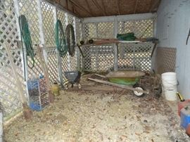 Barn area - wheels barrow, buckets, seeder, hoses, crates, and more