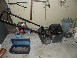 Murray push mover, tool box, other items on wall.