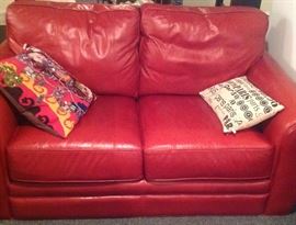 Broyhill red leather loveseat and sofa (not shown) and one of a pair of Alexander McQueen embellished pillows