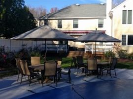 63" Tropitone Palazzo Tables, each with 6 Montreux Dining Chairs and Umbrellas.