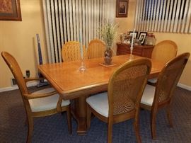 Trestle table with six neutral cane-backed chairs