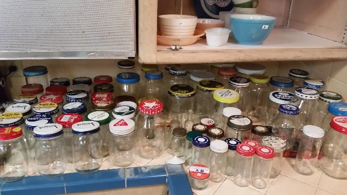 Dozens of vintage jars with advertising lids.