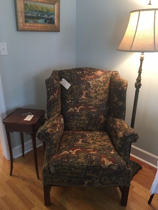 Wingback chair with Ralph Lauren fabric. Small wooden side table. Floor lamp.