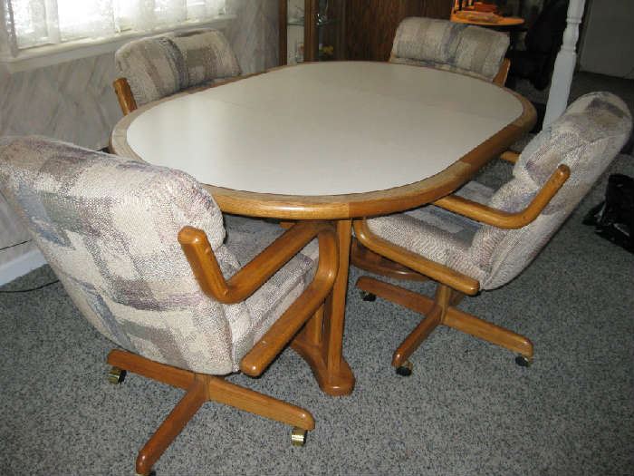 oval table and 4 padded rolling chairs