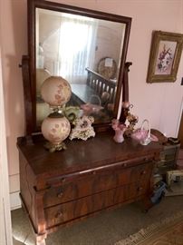 GORGEOUS dresser with a wonderfully aged mirror. Pink glass accents(Fenton hobnail) and a painted globe lamp adorn the top.