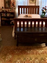 Golden-hued rug accents the dark wood of this antique bedroom suit with matching chest and dressing table .