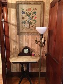 Vintage framed floral crewel piece Hangs above in Eastlake table and vintage mantle clock .