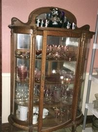 this curved glass oaken china cabinet features an outstanding collection of Fostoria, Fenton glass, American crystal , and Carnival glass