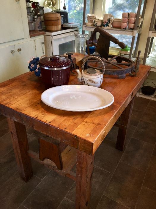 The real deal in "butcher block" is this antique table. Below it is an oak step stool on top is a whiteware platter, an unusual ceramic bucket, and a hoop cheese wheel & chop.. Wonderful pieces of Mexicana pottery on shelf at back window!!