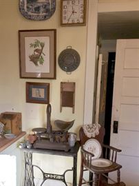 Antique oak high chair, is next to an iron singer sewing table with a scales on top.
