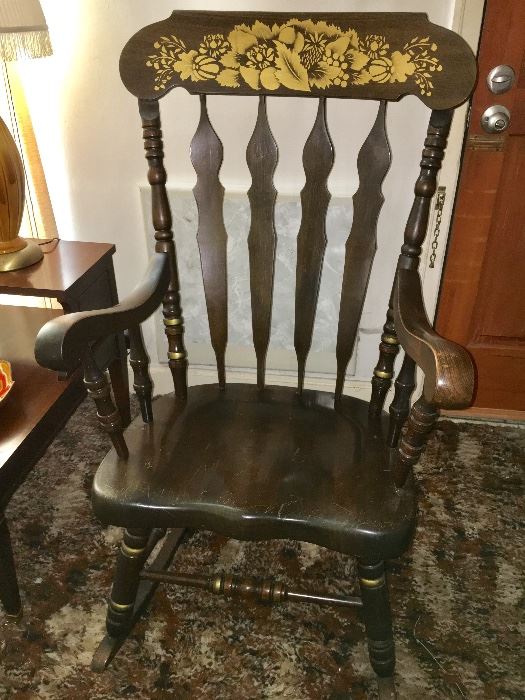 Vintage rocking chair with gold floral décor.