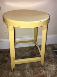 Vintage metal stool painted yellow.