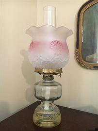 Antique oil lamp with frosted white and pink shade.