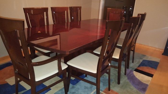 Stunning Milano Italian table with two leaves and eight chairs. Top has a clear laminate finish which prevents water staining/damage. 