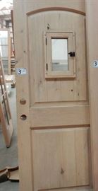 Knotty alder door with operable window over raised panel