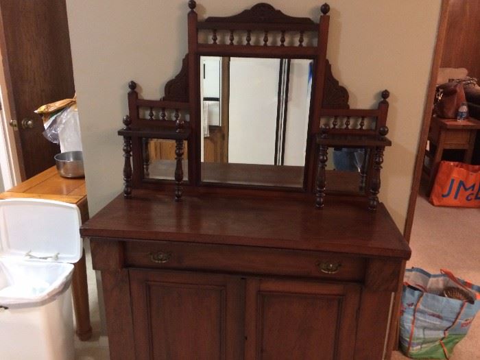 Antique buffet. The refrigerator is reflected in the mirror.