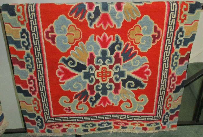 Tibetan rug (hanging over a railing in photo)