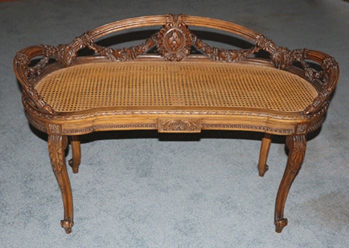 French Louis XV style Kidney Shaped bench.  Woven cane seat , Fancily carved with floral festoons. Ca. 1920.  Pristine condition!