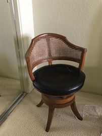 Swivel chair with leather seath and cane curved back