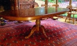 Ethan Allen wood pedestal table with extensions and pads. Round to Oblong in good condition. 