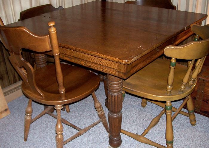 Sturdy square oak table has thick turned legs.  Assorted side chairs