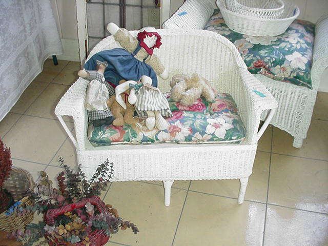Child's wicker settee and dolls