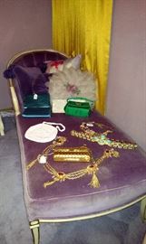 Purple velvet chaise lounge with jeweled belts and vintage purses