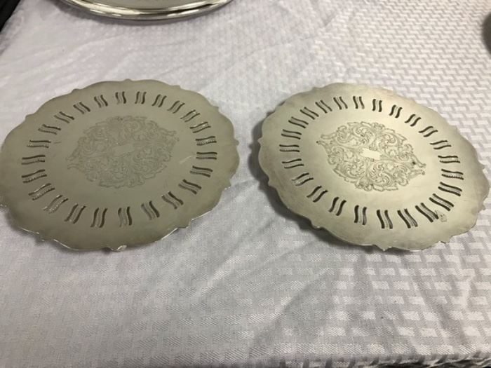 Pair of footed hot plates/trivets by Oneida Silversmiths. Measures 8.5" diameter