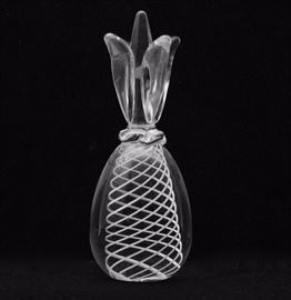 A signed Steuben glass pineapple figurine. Features a double helix design in white glass to the interior with a pineapple shape to the clear glass. The piece is signed Steuben to the bottom.

