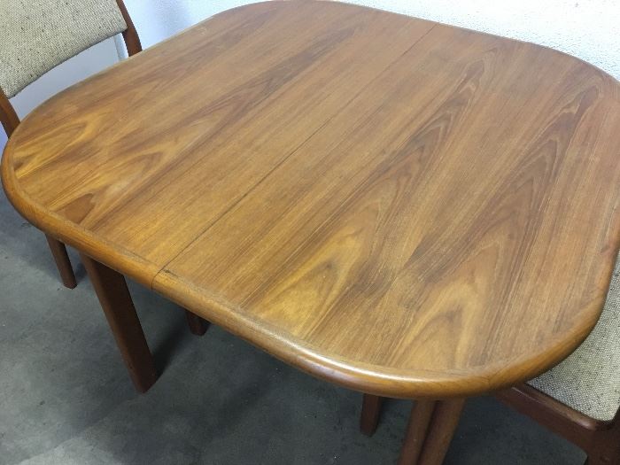 Mid Century modern Danish teak dining table and two matching upholstered teak chairs.
