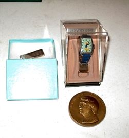 Tiffany & Co money clip, Jimmy Carter Inaugural coin and Donald Duck watch.