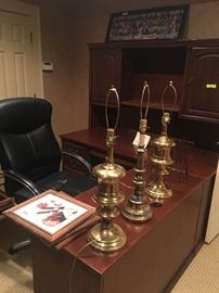 Corner executive desk with assorted brass lamps