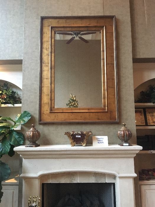 Stunning gold-toned great room mirror, assorted home decor items on fireplace mantel