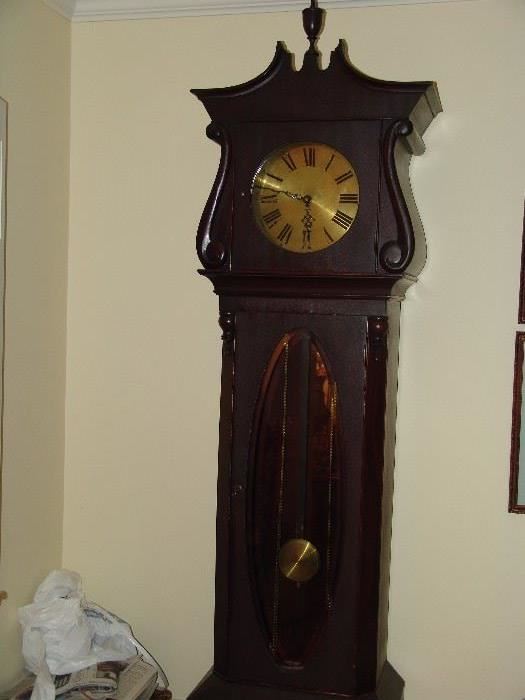Tall case clock with brass pendulum