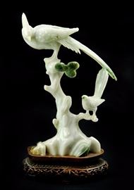26. JADE BIRDS AND PINE FIGURE翡翠 雙鳥朝鳳擺件Varying from a light milky green to rich green, this figurine depictes two birds perched on a pine tree branch. 568g H:8 1/2in W:5in
