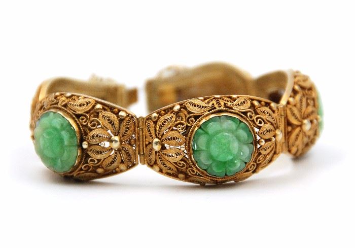 43. 19TH CENTURY GILT SILVER JADE BRACELET19世紀 翡翠金飾手鍊Fashioned from plated silver, this jointed cuff bracelet is an example of fine craftsmanship. It's composed of Five (5) joint pieces, Three (3) of which are inlaid with jade and have been carved with the likeness of a lotus flower in rotational symmetry. Each link has been covered in a very fine metal mesh and adorned with floral imagery that is reminiscent of the Hong Kong orchid.44 g   L:3 1/2 in