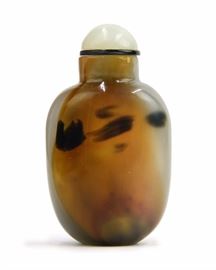 54. MOULDED GLASS SNUFF BOTTLE玻璃胎斑點鼻煙壺With caramel and black colored inclusions, this snuff bottle has a pale green stopper. 48g
H:2 3/4in