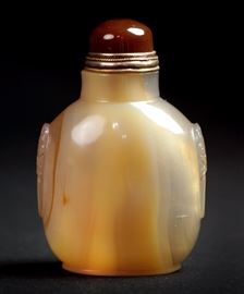 55. ANIMAL MASK SNUFF BOTTLE瑪瑙鼻煙壺Carved with animal masks on both sides, this agate snuff bottle has a carnelian stopper. H: 3 1/8 in
W: 2 1/8 in 94g