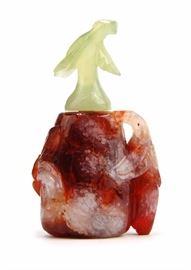 57. FLOWER AGATE SNUFF BOTTLE瑪瑙雕花鼻煙壺With a body carved from red and white flower agates and a green jadiete stem stopper.95g
H:3 1/8in