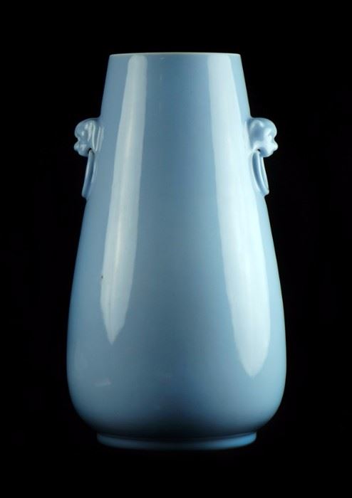 106. LIGHT BLUE GLAZED VASE“大清雍正年制”款 藍釉獸耳瓶Even in color and with a wider base than mouth, this vase has been moulded with animal mask handles at the side.H:15 in
W: 7 3/4 in
MOUTH: 5 in
