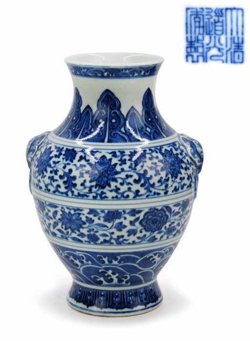 111. MING-STYLE BLUE & WHITE BALUSTER BASE, DAOGUANG SEAL MARK AND OF THE PERIOD (1782-1850)清  “大清道光年制”款以及其年代,青花獸耳瓶A ming style blue and white vase with taotie beast ring handles molded at the side. Banana leaf motifs ring around the neck, and the body is covered in sections of curling vines and florals along with a band of water patterns near the foot.  (1782-1850). H: 9 7/8 in W:6 7/8 in M: 3 5/8 in
